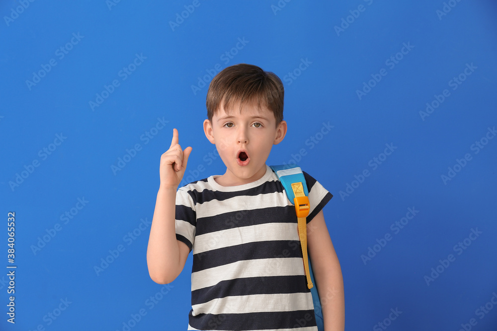 Little schoolboy with raised index finger on color background Little schoolboy with raised index finger on color background