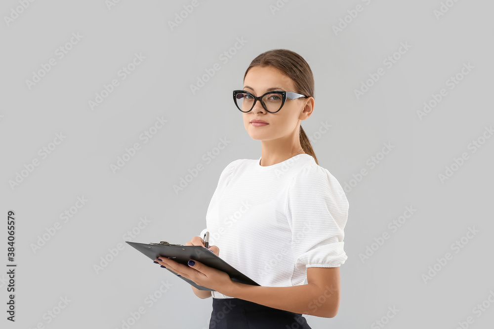 Portrait of young businesswoman on light background