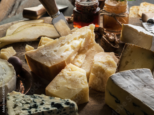 Cheese platter with different cheeses, fruits and jam on stone background. Tasty cheese starter.