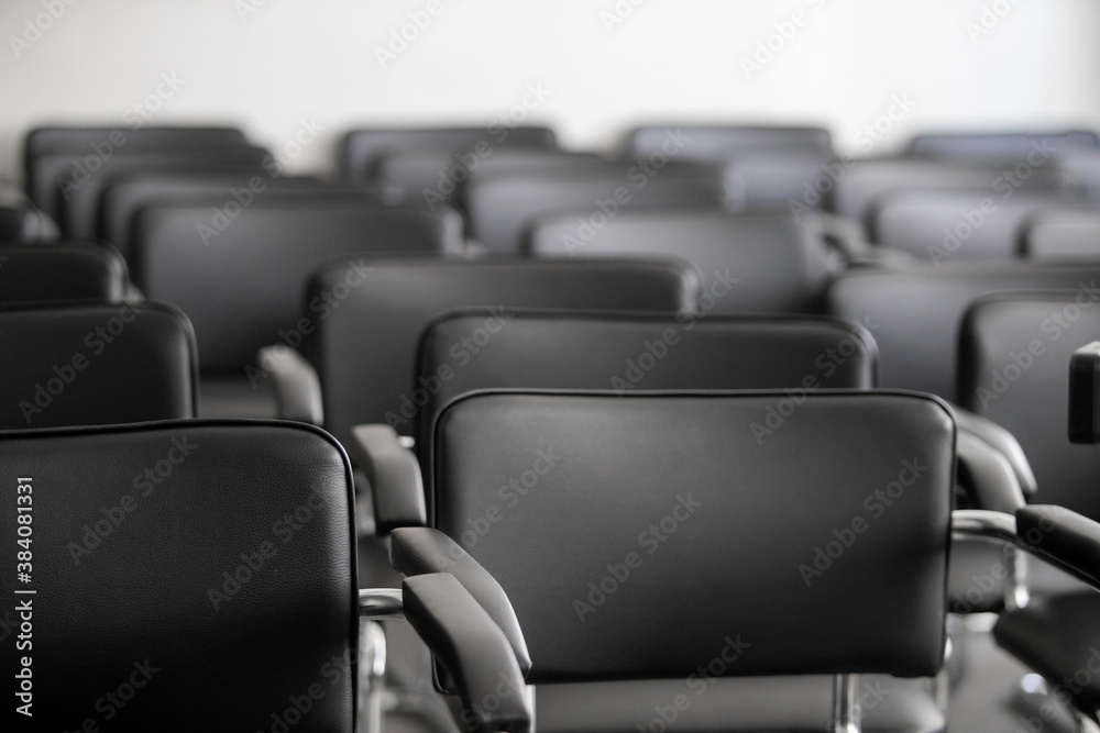 Empty black chairs stand in conference hall Empty black chairs stand in conference hall