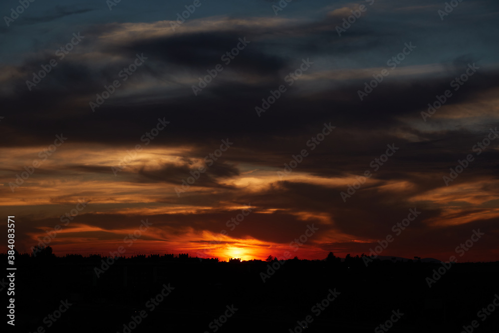 The reddish colors of the sun reflected in the clouds at a sunset in Madrid. Spain