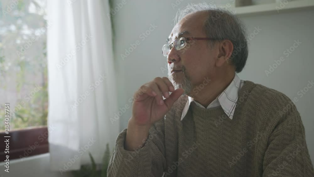 Close up : Sad old retired gray haired grandpa asian man sitting alone at table desk at window boring stay home self isolation quarantine feeling depress in problem mental health.