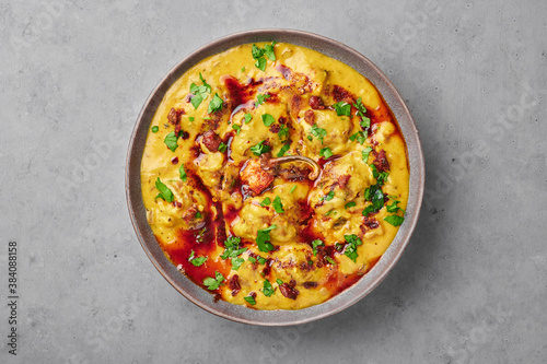 Punjabi Kadhi Pakora in gray bowl on concrete table top. Kadhi Pakoda is indian cuisine curry dish. Asian food and meal photo