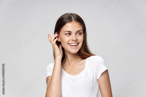 Cheerful woman straightens her hair smile white t-shirt 