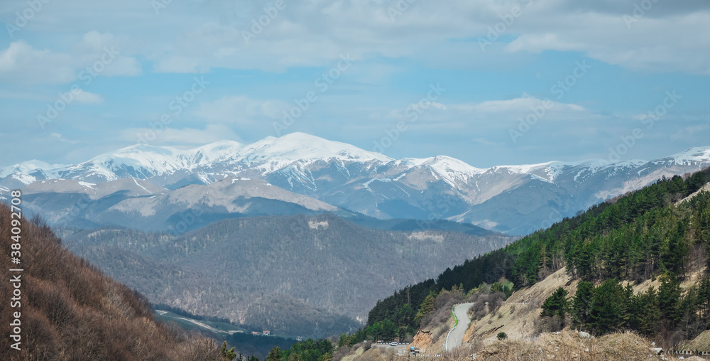 Road through mountains and forest captured from above. view from the top of the mountain,snow-capped mountains.