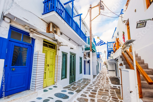Old Traditional greek street of Mykonos with white houses colourful doors and balconies  Greece