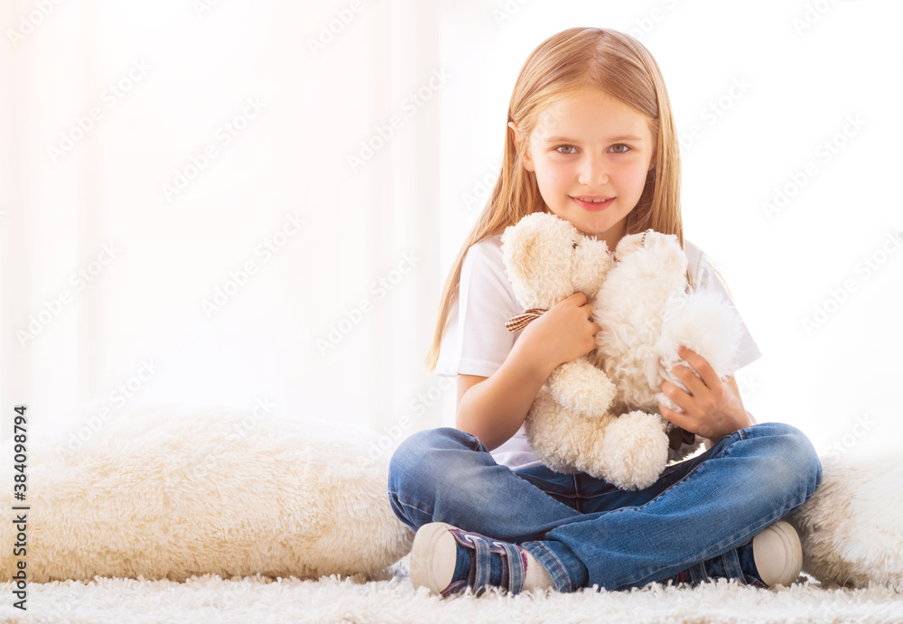 Cute girl hugging toys sitting on carpet in her room Cute girl hugging toys sitting on carpet in her room