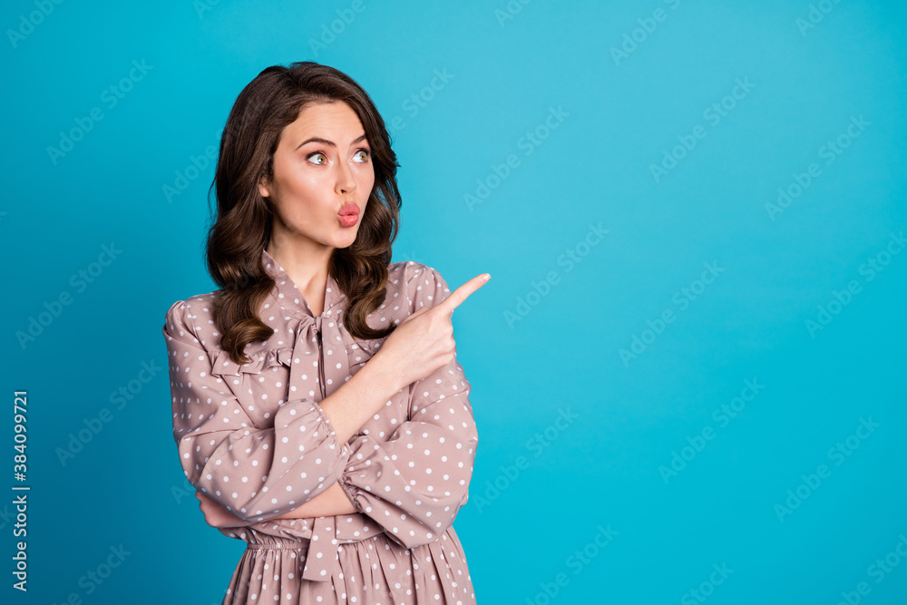 Portrait of astonished lovely girl lips pouted plump indicate sales discount adverts promotion point index finger copyspace wear dotted shirt isolated over blue color background Portrait of astonished lovely girl lips pouted plump indicate sales discount adverts promotion point index finger copyspace wear dotted shirt isolated over blue color background