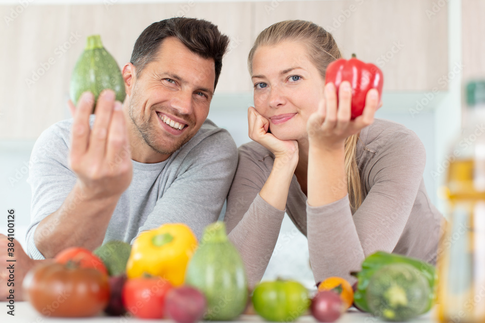 Fototapeta premium couple holding vegetables to promote healthy eating at home