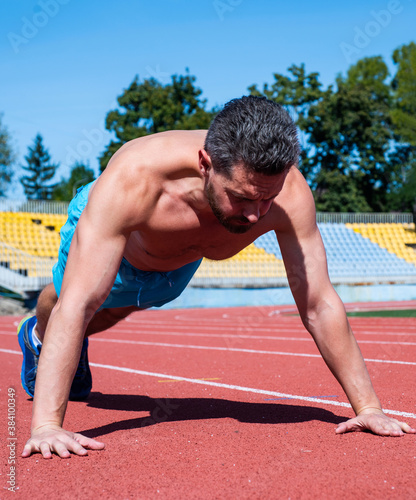 muscular man stand in plank making push up on sport training, power