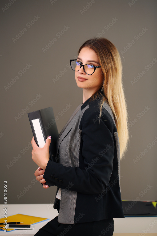 young beauty in the office and jacket holding documents