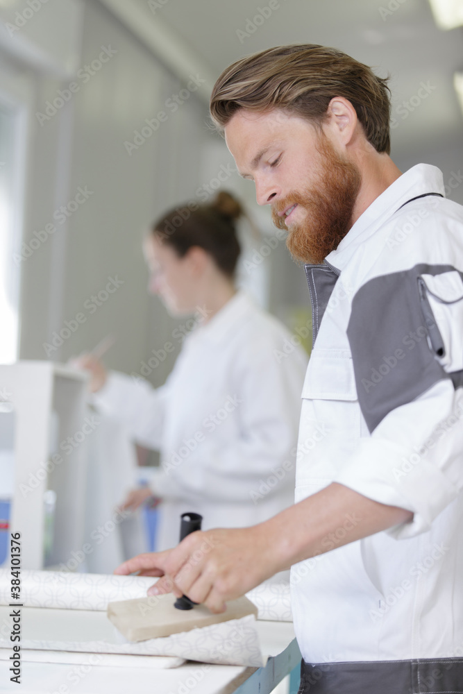 bearded decorator applying wallpaper paste bearded decorator applying wallpaper paste
