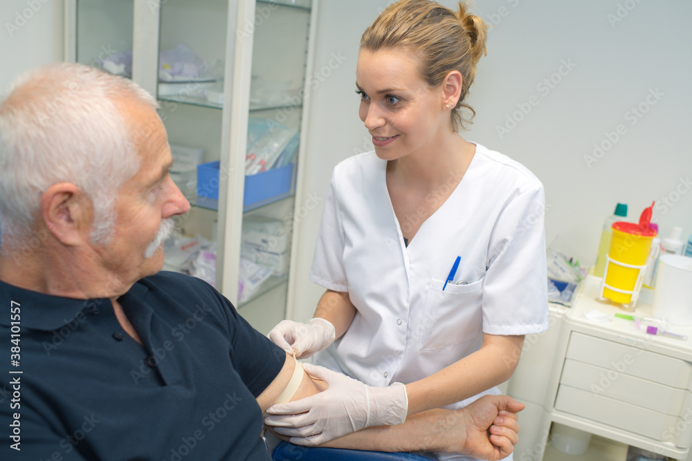 Fototapeta premium nurse releasing tourniquet from patients arm