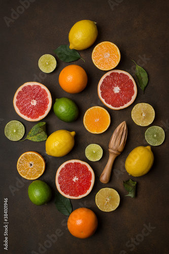 Orange, lemon, grapefruit, lime, mandarin different citrus fruits on a dark brown background, top view.