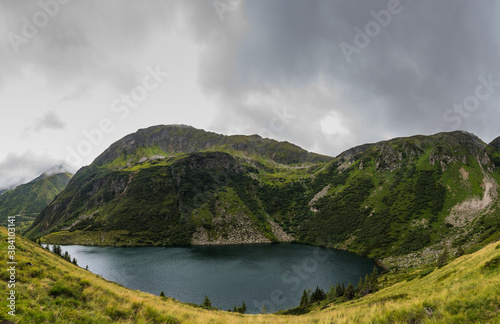 beautiful mountain lake in a green mountain range panorama