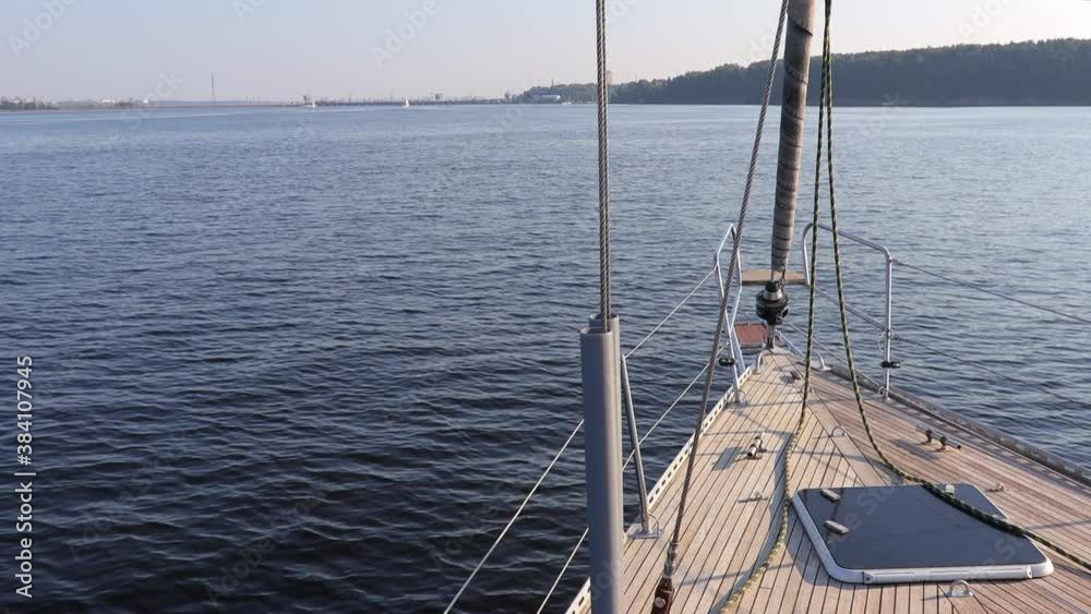 A view from the yacht's deck to the bow and sails on river. rest on a yacht A view from the yacht's deck to the bow and sails on river. rest on a yacht