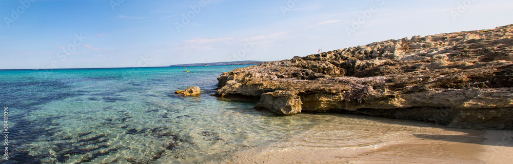 Strolling through Rompeaolas on the beach of Illetes (Formentera-Spain)