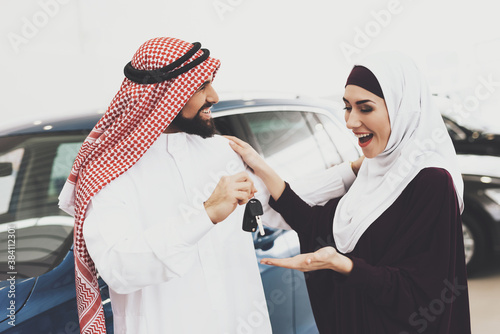 Man smiles and gives his wife the keys to new car. photo