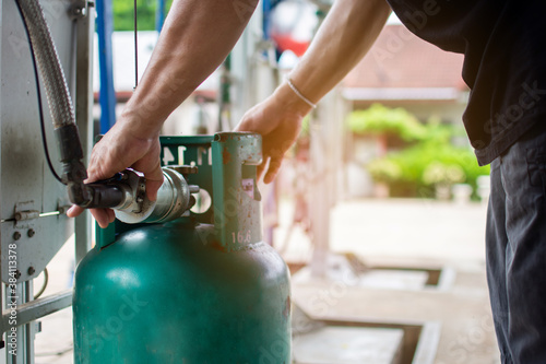 A male worker uses a gas cylinder device for a customer.