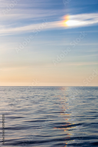 Halo with sun dog and colorful reflections in the sea