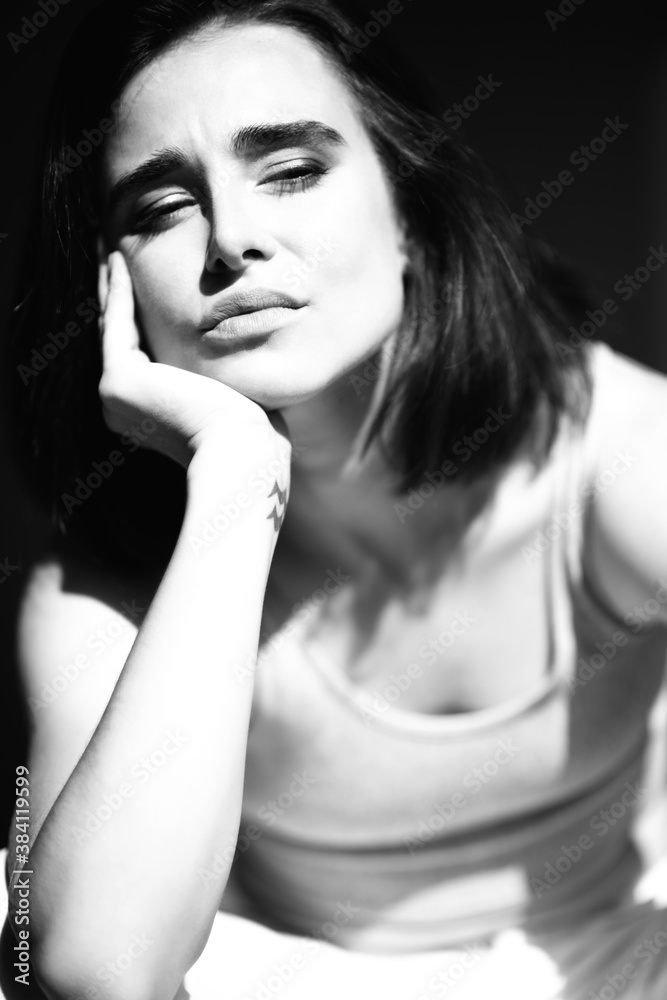 Beautiful young woman. Black and white portrait of charming girl wearing casual clothes posing at home Beautiful young woman. Black and white portrait of charming girl wearing casual clothes posing at home
