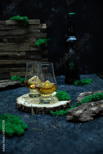 Two glasses of whiskey served on a wooden slice