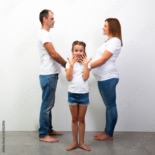 Wife and husband with little happy daughter expecting baby. photo