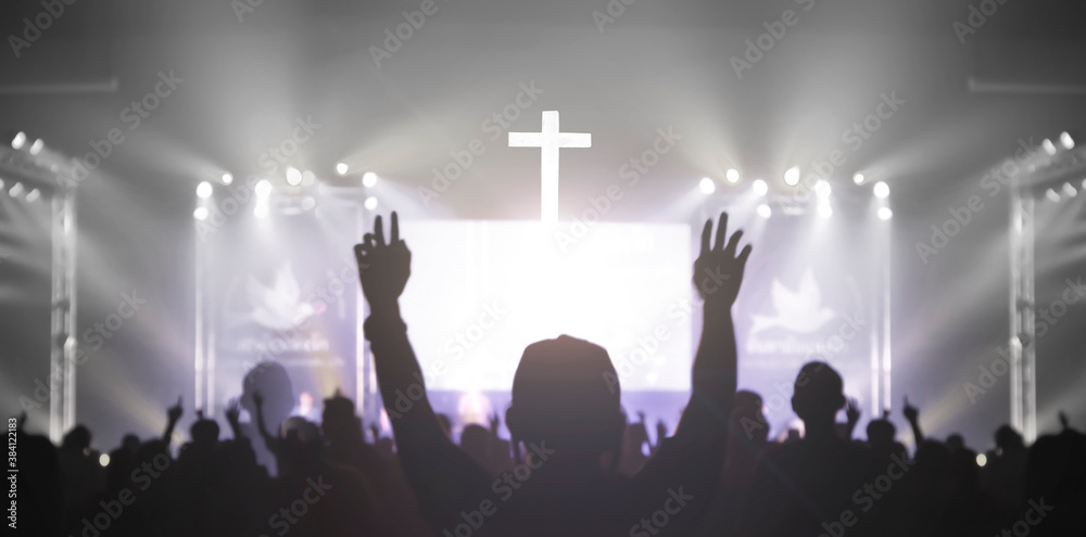 Church worship concept: Christian worship with raised hand at the at the cross cross background