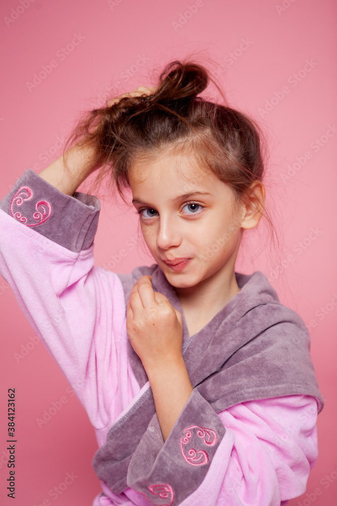 a girl dressed in a terry bathrobe straightens her hair a girl dressed in a terry bathrobe straightens her hair