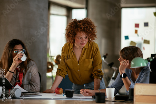 Businesswomen working on a new project. Colleagues discussing work in office © JustLife