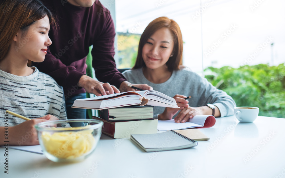 Group of young students tutoring and catching up workbook together Group of young students tutoring and catching up workbook together
