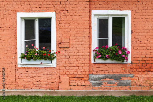 Two white windows in old red brick wall