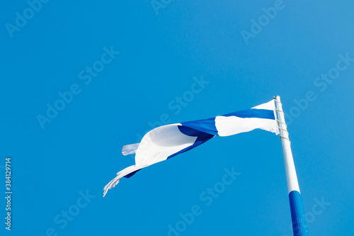 The largest finnish flag in the world and the tallest flagpole in Europe against blue sky, Hamina, Finland. The flag pole is 100 meter high. photo