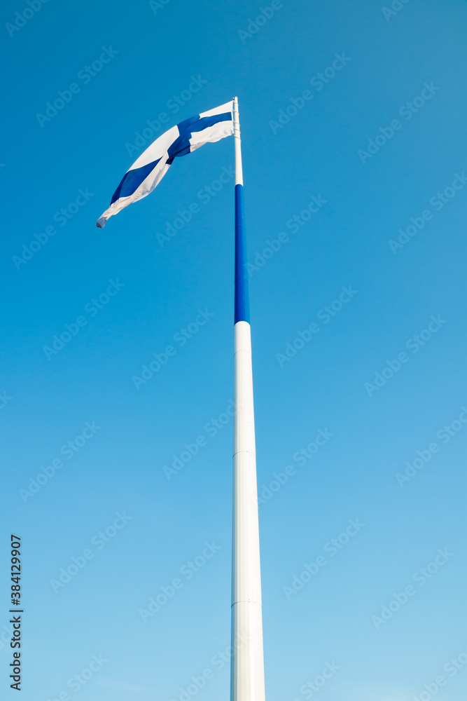 The largest finnish flag in the world and the tallest flagpole in Europe against blue sky, Hamina, Finland. The flag pole is 100 meter high. The largest finnish flag in the world and the tallest flagpole in Europe against blue sky, Hamina, Finland. The flag pole is 100 meter high.