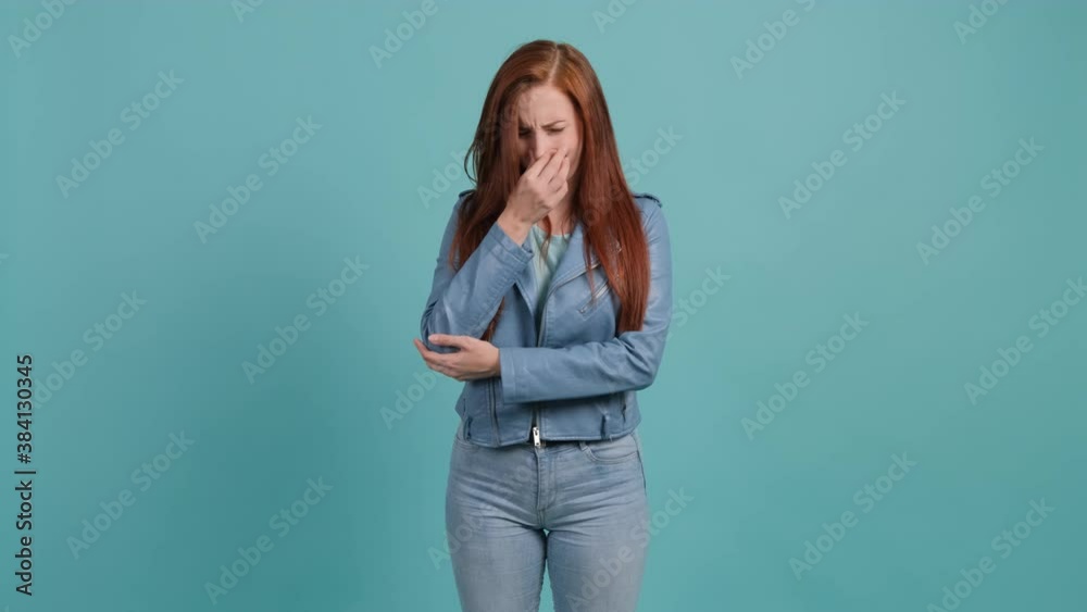 Caucasian young woman that is showing disgust, pinching her nose to avoid bad smell. Negative emotions, nasty feelings.