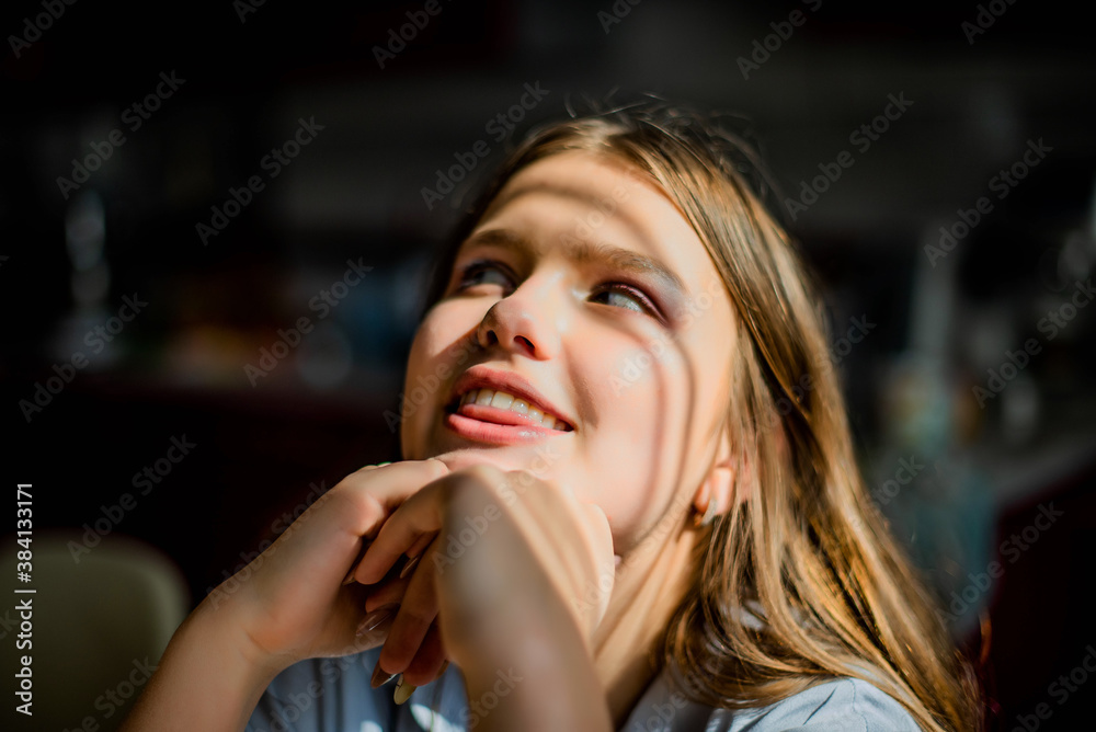 Fototapeta premium Fashion lifestyle image of pretty teenage young woman sitting in kitchen.