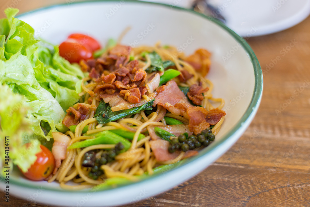 Organic chinese kale and crispy bacon spaghetti on a wooden table. Organic chinese kale and crispy bacon spaghetti on a wooden table.