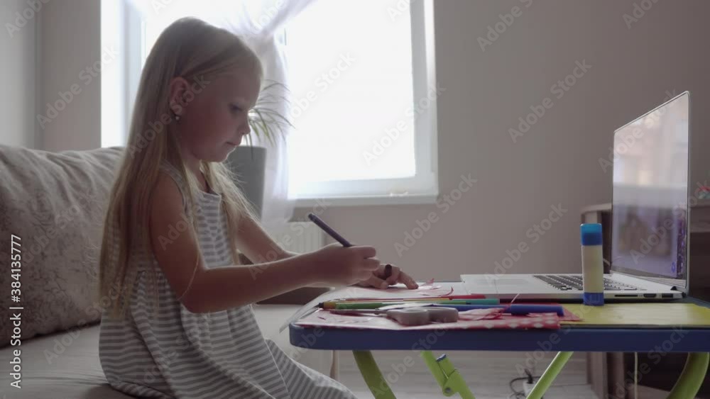 A child at home to watch an online lesson remotely. Self-isolation and online education concept caused by coronavirus pandemia