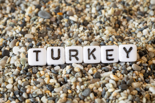 Turkey inscription text with name of the vacation destination city in a still life of the letters laid out on a shore sand stones.