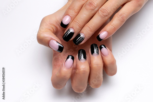  Gel design. Black French manicure with silver stripes on long square nails on a white background close-up.