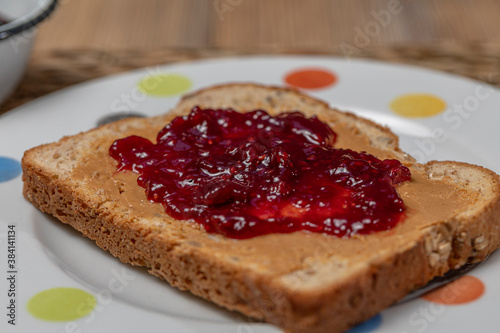 Breakfast. Peanut butter and raspberry jelly sandwich on wooden background.