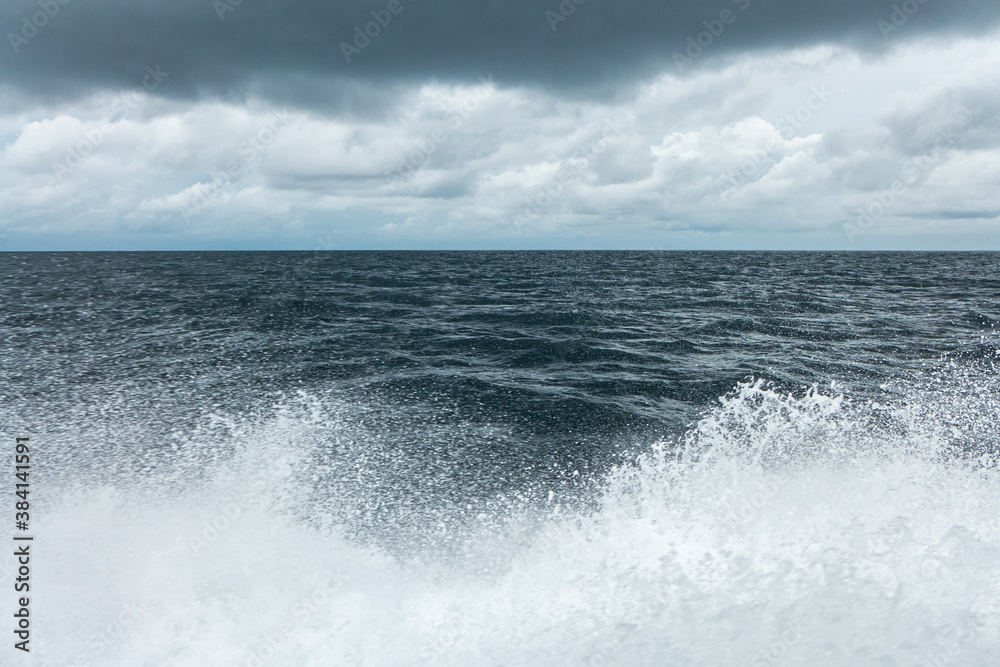 Grey ocean water splashes under cloudy grey sky shot from a speed boat on Maldive islands Grey ocean water splashes under cloudy grey sky shot from a speed boat on Maldive islands