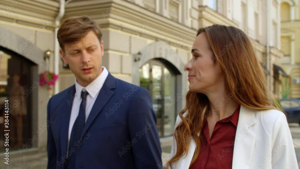 Successful business couple walking together outdoors. Business partners talking Successful business couple walking together outdoors. Business partners talking