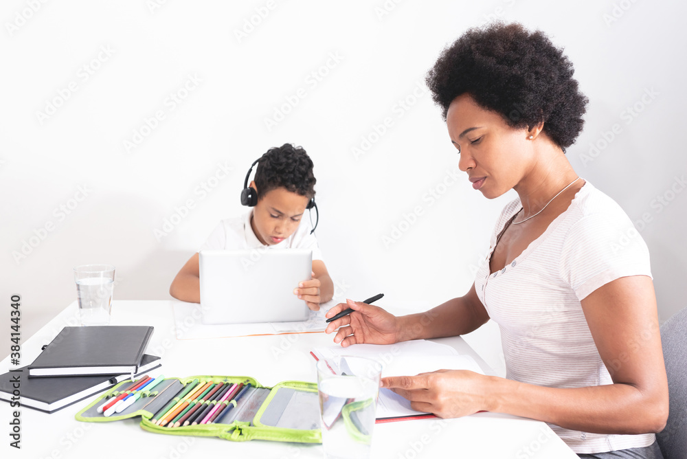 Boy attending his online classes while mother works from home Boy attending his online classes while mother works from home