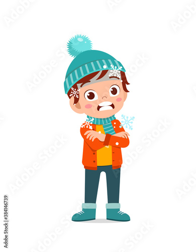 happy cute little kid play and wear jacket in winter season. child feeling chill wearing warm clothes