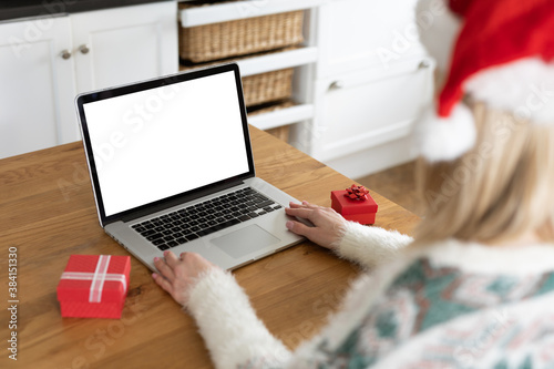 Woman wearing Santa hat using laptop at home