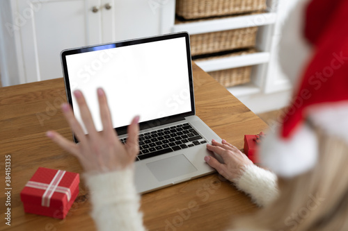 Woman wearing Santa hat using laptop at home