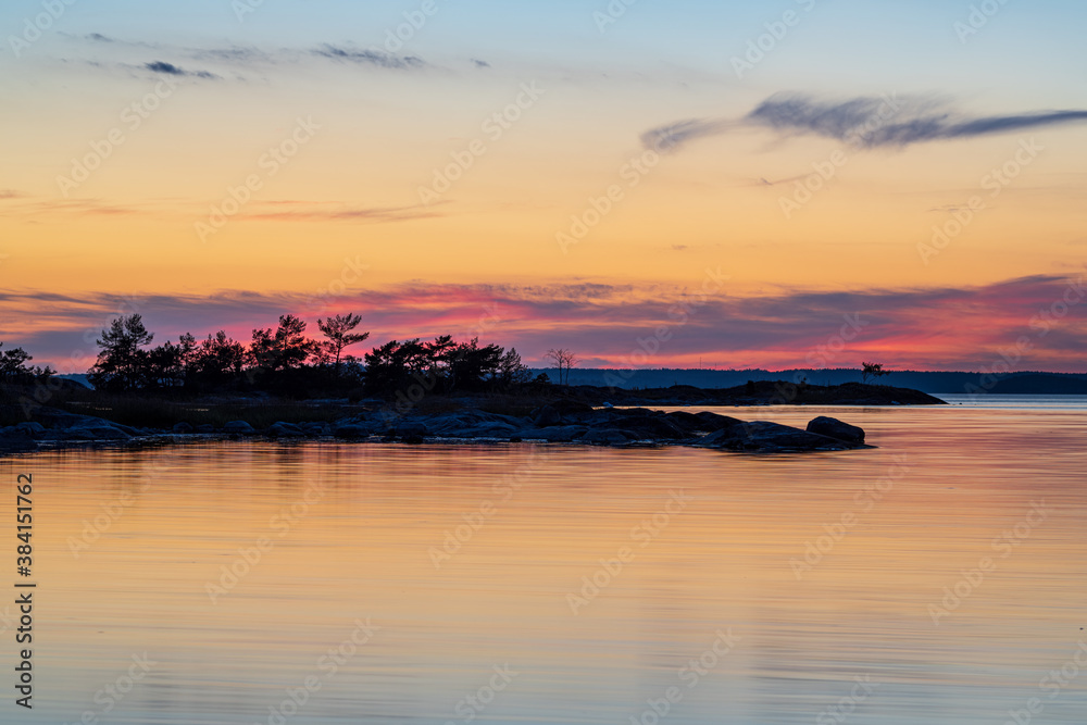 Scenic view of a coastline with trees at sunset in Stockholm archipelago, Sweden