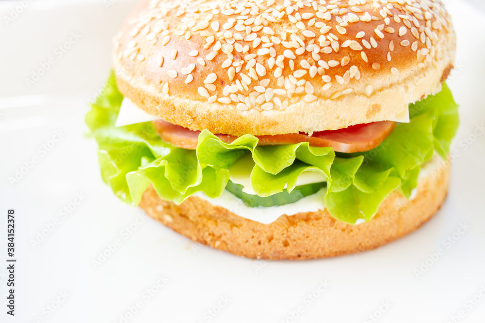 Burger with lettuce and sesame seed bun. Burger with lettuce and sesame seed bun.