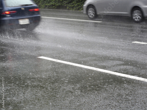 雨天走行中の自動車の水しぶき © Paylessimages